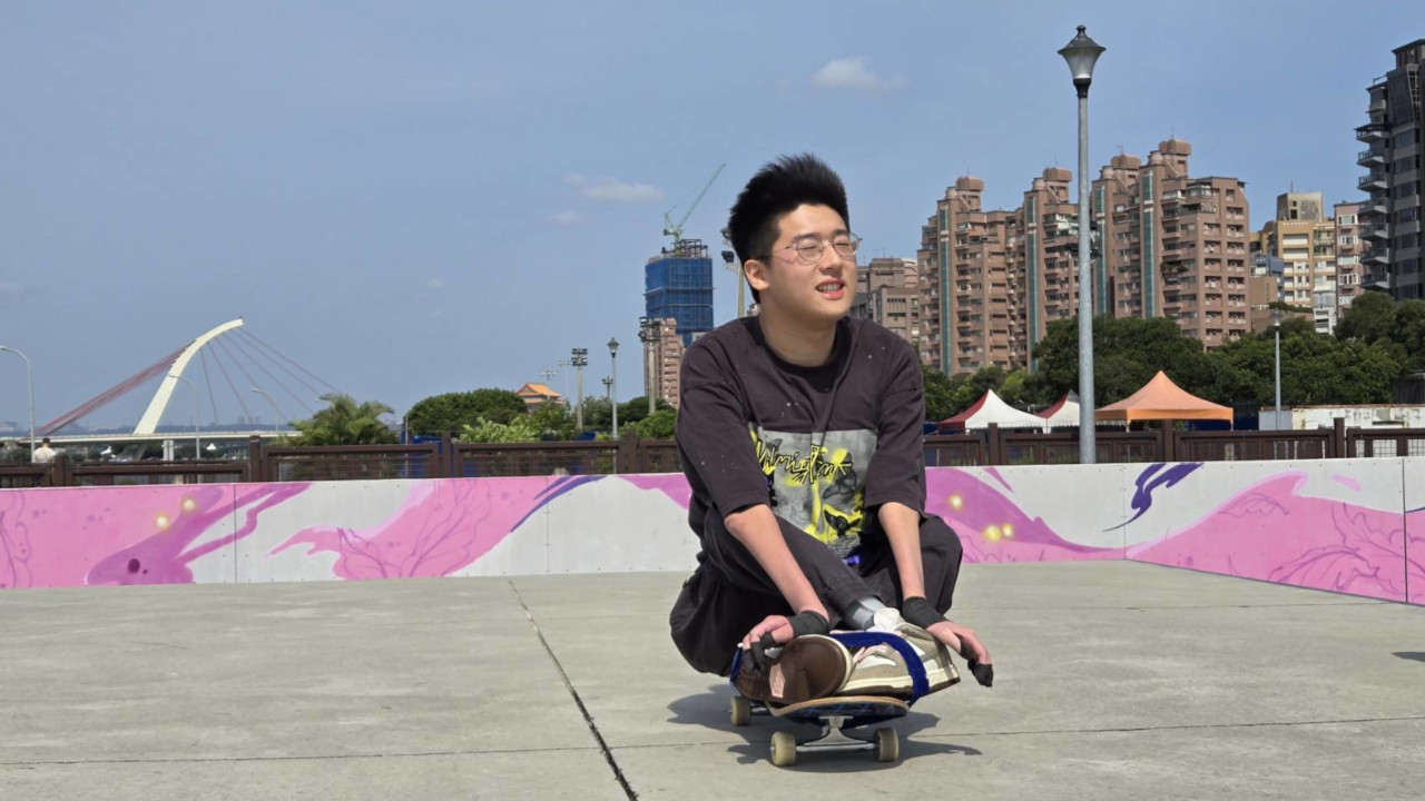 文凱坐在滑板上享受微風輕撫他的臉