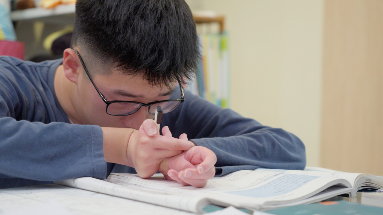 即便四肢末梢退化沒有力氣，文凱還是努力的寫好每一份功課